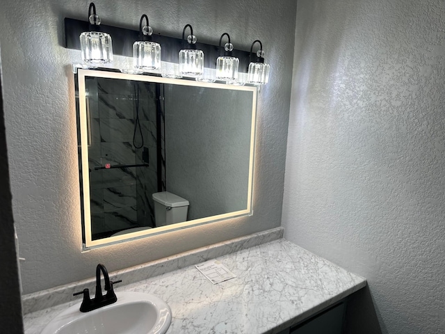 bathroom featuring a shower, toilet, and vanity