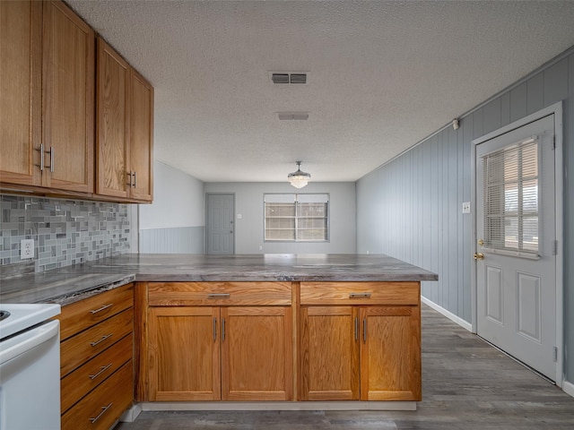 kitchen with kitchen peninsula, white range with electric cooktop, dark wood-type flooring, and a textured ceiling
