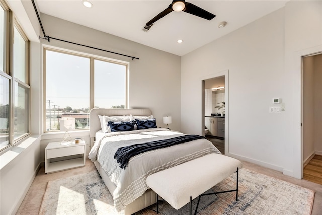 bedroom featuring ceiling fan, connected bathroom, and multiple windows