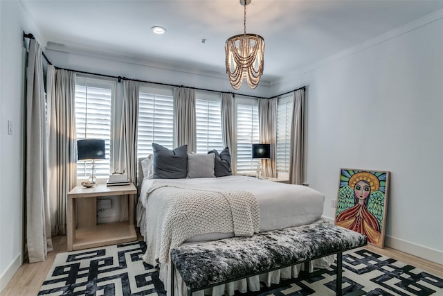 bedroom with light hardwood / wood-style flooring, a notable chandelier, and crown molding