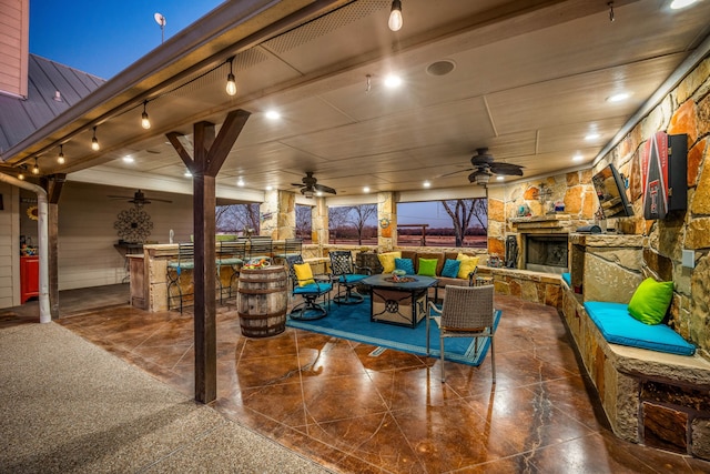 view of patio / terrace with an outdoor living space with a fireplace and ceiling fan