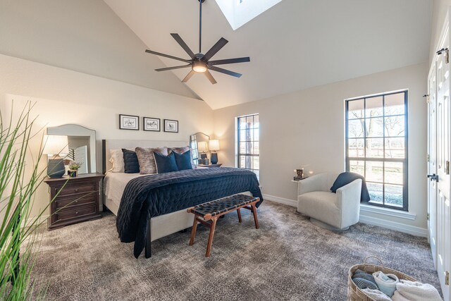 bedroom with multiple windows, carpet flooring, a skylight, and ceiling fan