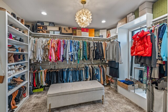 spacious closet with carpet and a notable chandelier