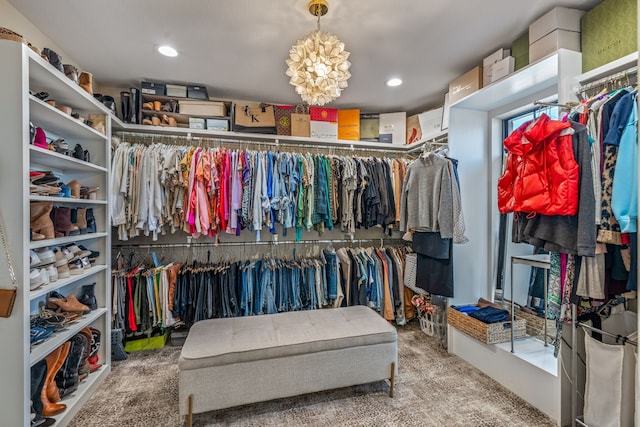 spacious closet with a notable chandelier and carpet flooring