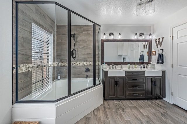 bathroom with vanity, a textured ceiling, and bath / shower combo with glass door