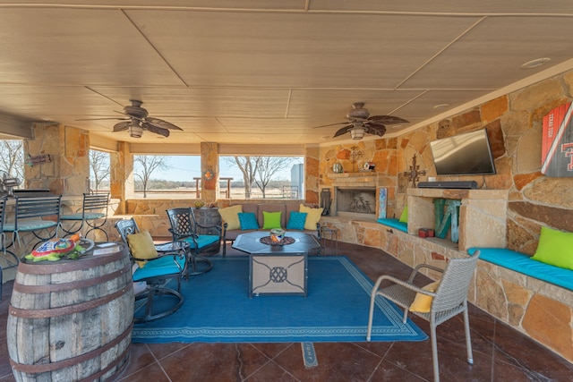 view of patio featuring an outdoor stone fireplace and ceiling fan