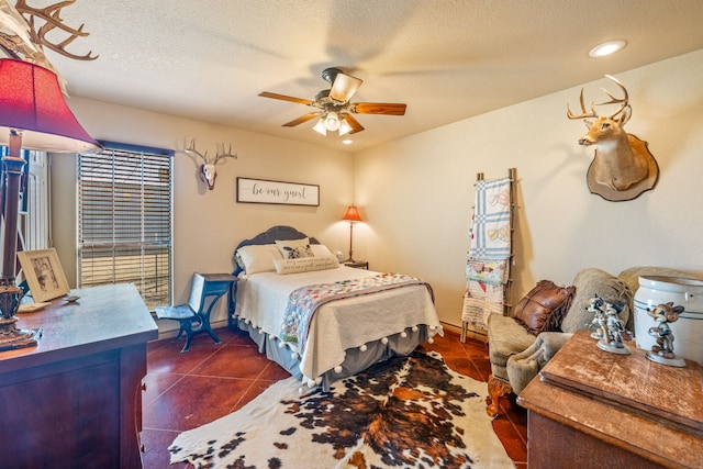 tiled bedroom featuring ceiling fan and a textured ceiling