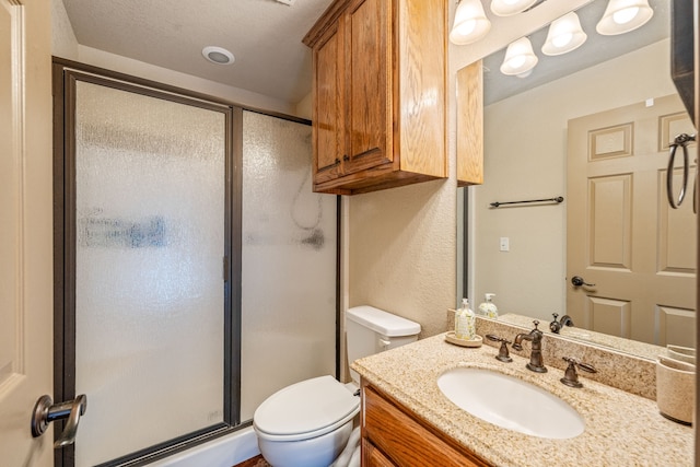 bathroom featuring vanity, toilet, and a shower with door