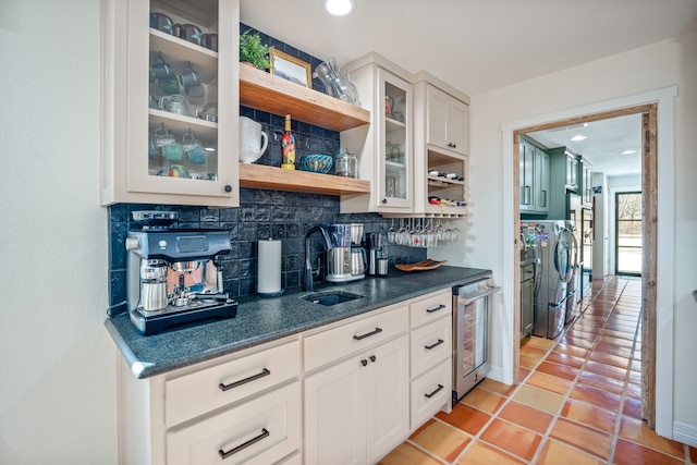 kitchen with white cabinets, tasteful backsplash, beverage cooler, and sink