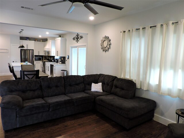 living room with ceiling fan and dark hardwood / wood-style flooring