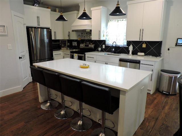 kitchen featuring sink, tasteful backsplash, decorative light fixtures, a kitchen island, and stainless steel appliances