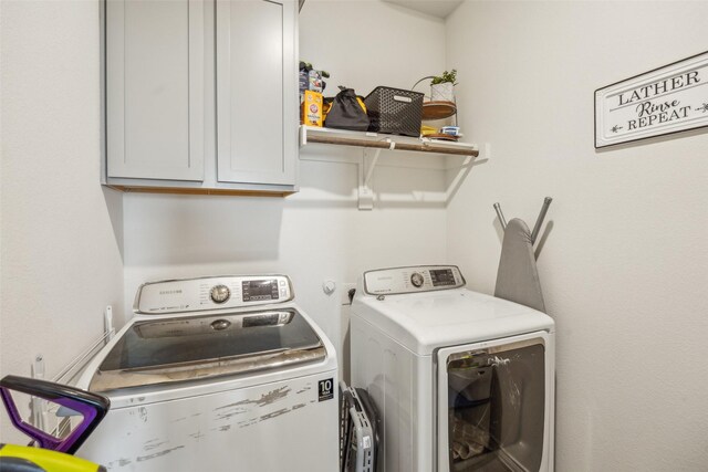 laundry area featuring washer and dryer and cabinets