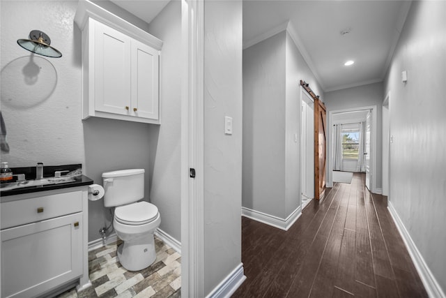 bathroom with vanity, hardwood / wood-style flooring, toilet, and crown molding