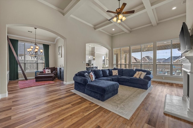 living room featuring beamed ceiling, wood-type flooring, coffered ceiling, and a high ceiling