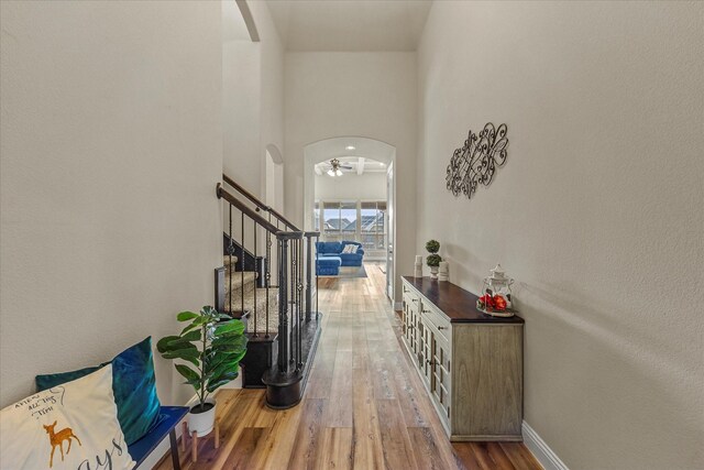 living room with beamed ceiling, hardwood / wood-style floors, ceiling fan with notable chandelier, and coffered ceiling