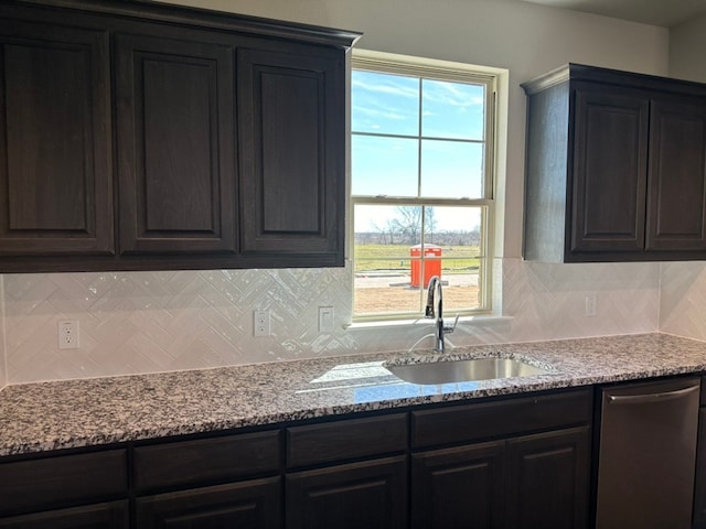 kitchen featuring a sink, light stone countertops, decorative backsplash, and dishwasher