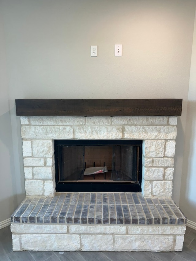 room details featuring a fireplace with raised hearth and baseboards