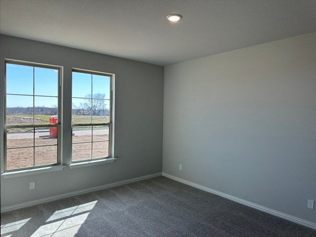 empty room with recessed lighting, dark carpet, and baseboards