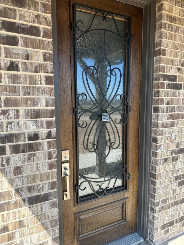 doorway to property with brick siding