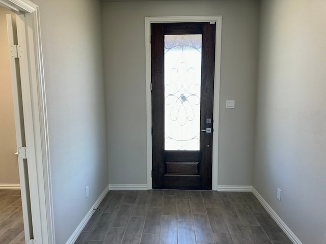 foyer entrance featuring baseboards and dark wood finished floors