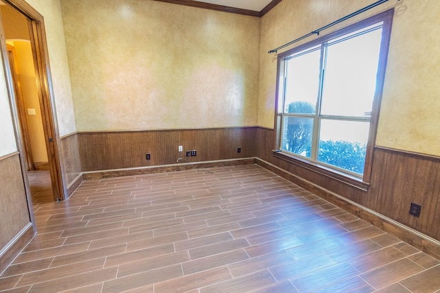 spare room featuring a wainscoted wall, wood walls, and wood tiled floor