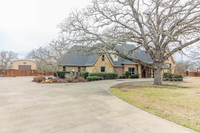 view of front of property with driveway, fence, a front lawn, and brick siding