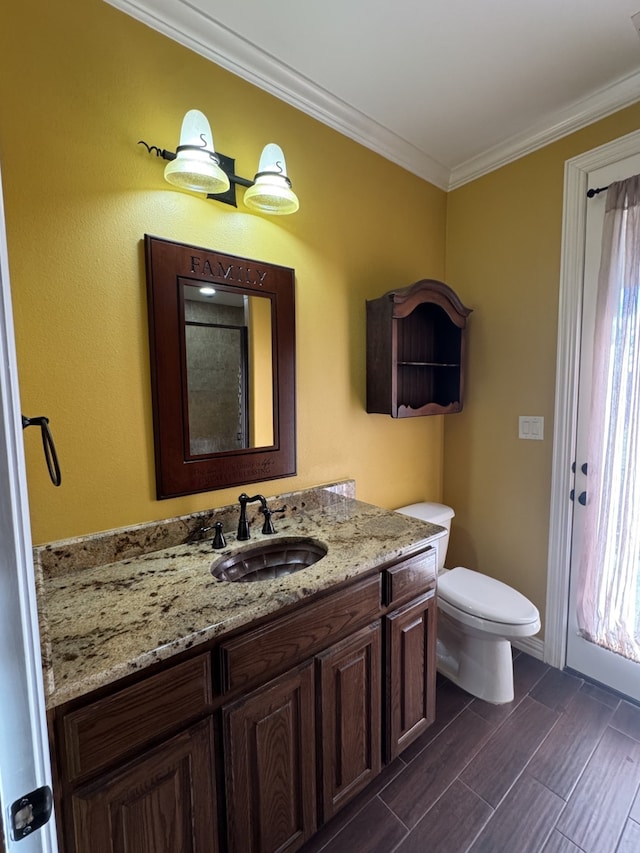 bathroom with vanity, a wealth of natural light, ornamental molding, and toilet