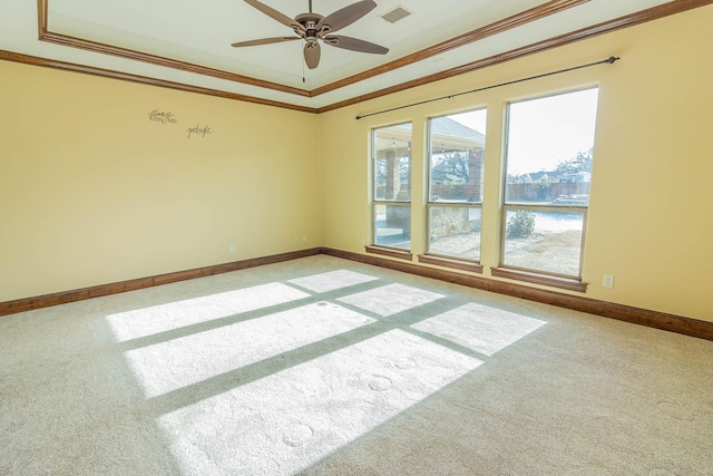 carpeted spare room with ornamental molding, visible vents, ceiling fan, and baseboards