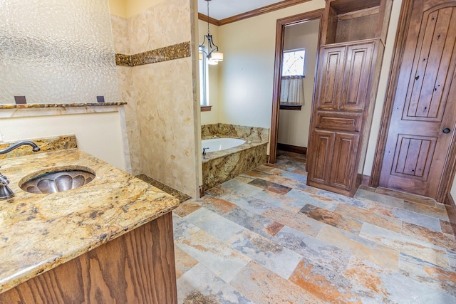 bathroom with stone tile floors, baseboards, crown molding, vanity, and a bath