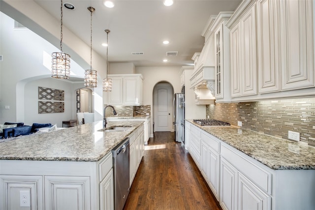 kitchen featuring light stone counters, stainless steel appliances, a spacious island, pendant lighting, and a chandelier