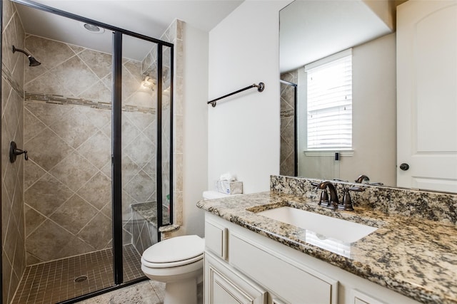 bathroom featuring walk in shower, vanity, and toilet