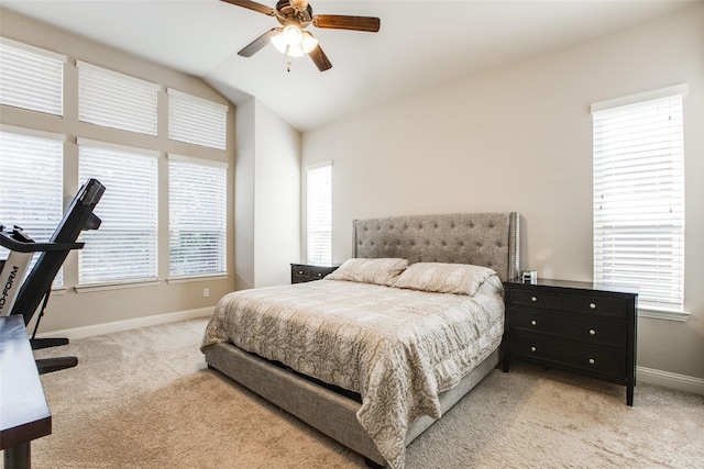 bedroom featuring multiple windows, ceiling fan, light carpet, and lofted ceiling