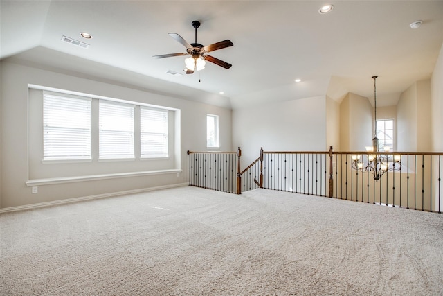 spare room with ceiling fan with notable chandelier, lofted ceiling, and carpet floors