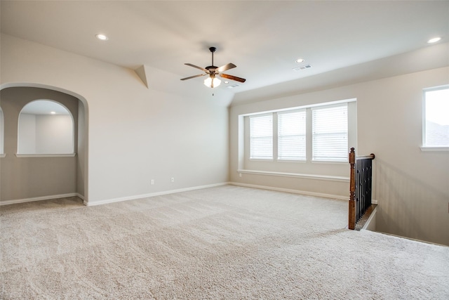 carpeted spare room with ceiling fan and a wealth of natural light