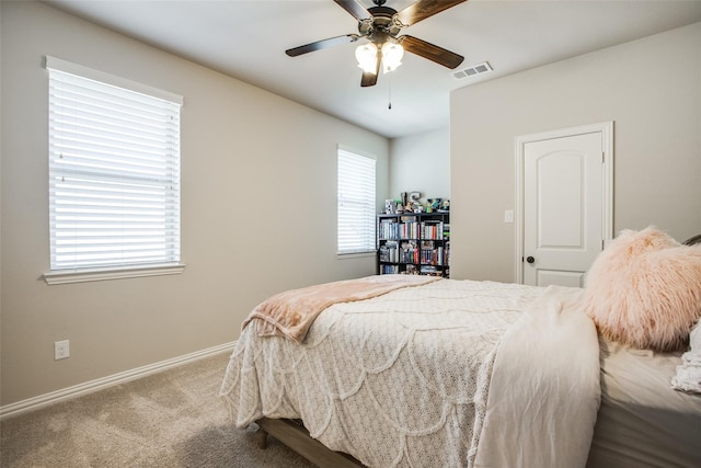 carpeted bedroom featuring multiple windows and ceiling fan