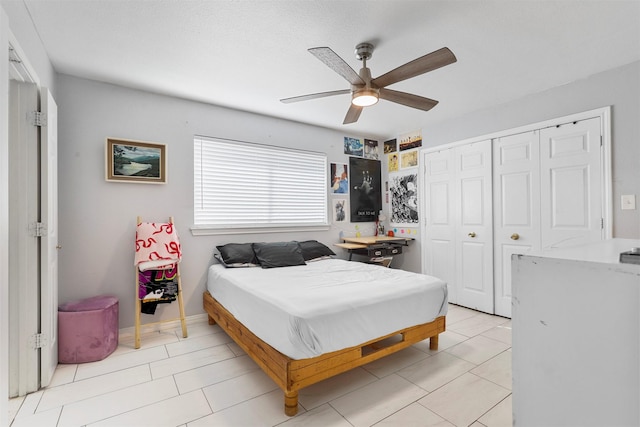 tiled bedroom with ceiling fan and a closet