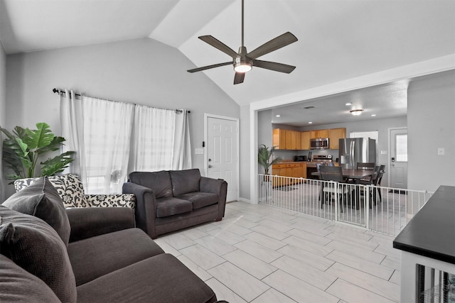 living room featuring ceiling fan and vaulted ceiling