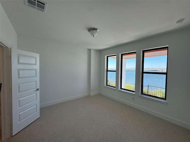 spare room featuring carpet flooring and a water view