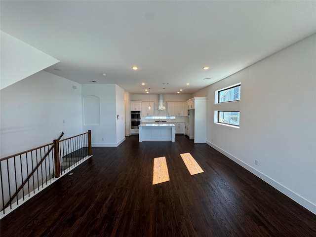 unfurnished living room featuring sink and dark hardwood / wood-style floors