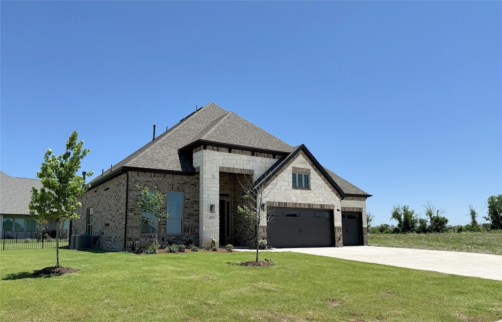 203 Links Ct, Heath, TX 75032 - french country home with concrete driveway, stone siding, central AC unit, an attached garage, and brick siding