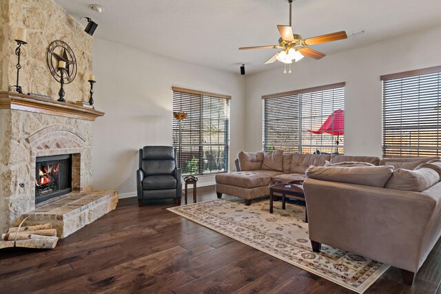 living room featuring dark hardwood / wood-style flooring, ceiling fan, and a fireplace