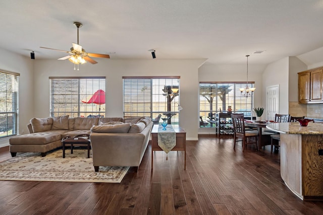 living room featuring dark hardwood / wood-style floors, ceiling fan with notable chandelier, and a wealth of natural light