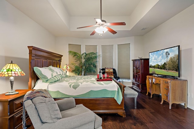 bedroom featuring a tray ceiling, ceiling fan, and dark hardwood / wood-style floors