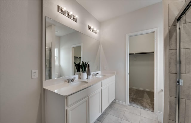 bathroom featuring tile patterned floors, a shower with door, and vanity