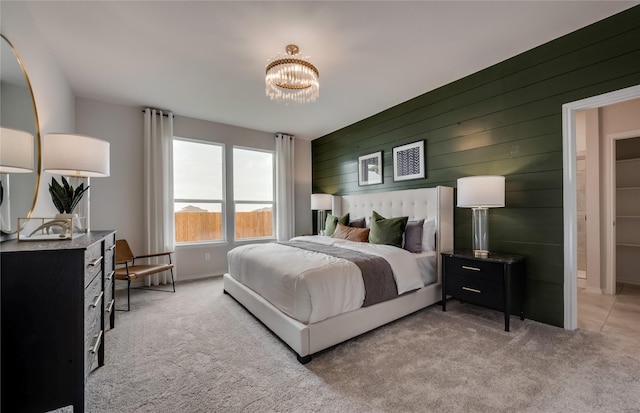 carpeted bedroom featuring a notable chandelier and wood walls