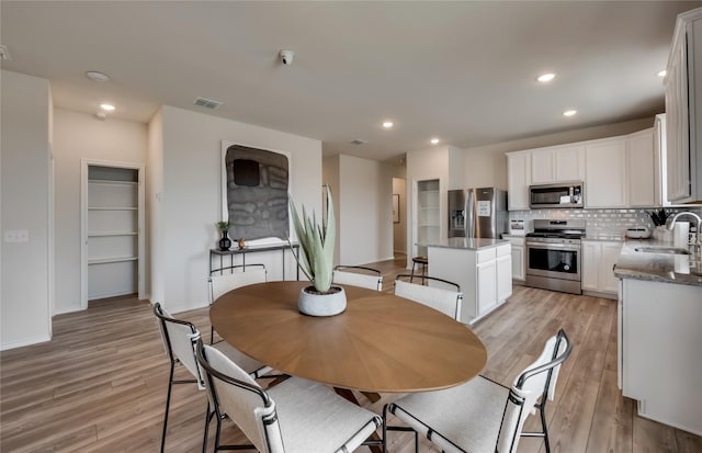 dining room featuring light wood-type flooring and sink