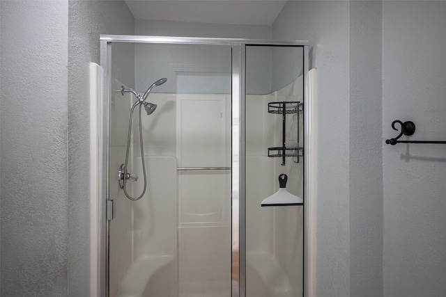 bathroom featuring a shower with door