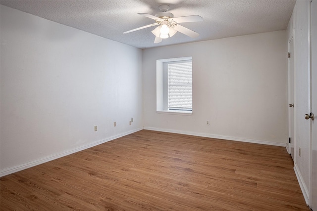 spare room with ceiling fan, a textured ceiling, and hardwood / wood-style flooring