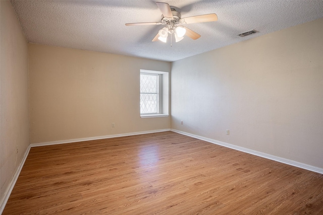 empty room featuring ceiling fan, light hardwood / wood-style floors, and a textured ceiling