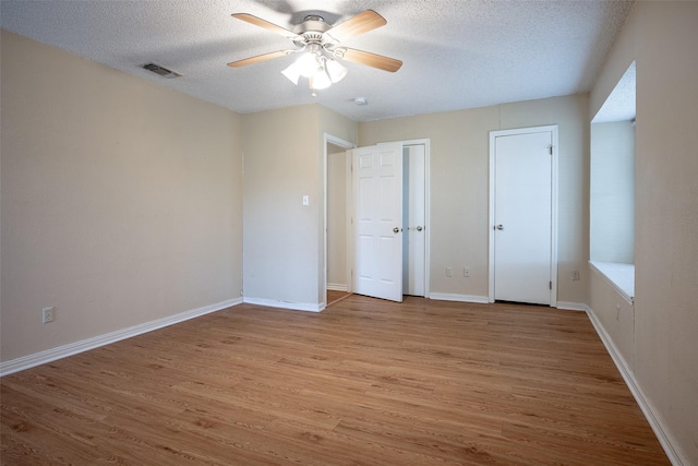 unfurnished bedroom featuring a textured ceiling, light hardwood / wood-style floors, and ceiling fan